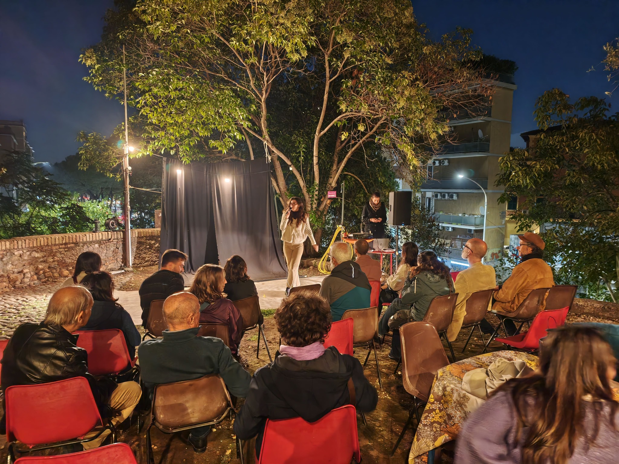 People sitting and listening to someone with a microphone
