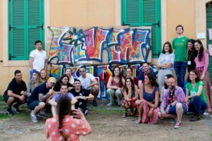 Group picture of volunteers in front of a graffiti