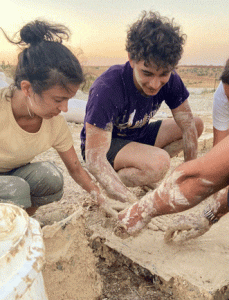 2 people working with mud