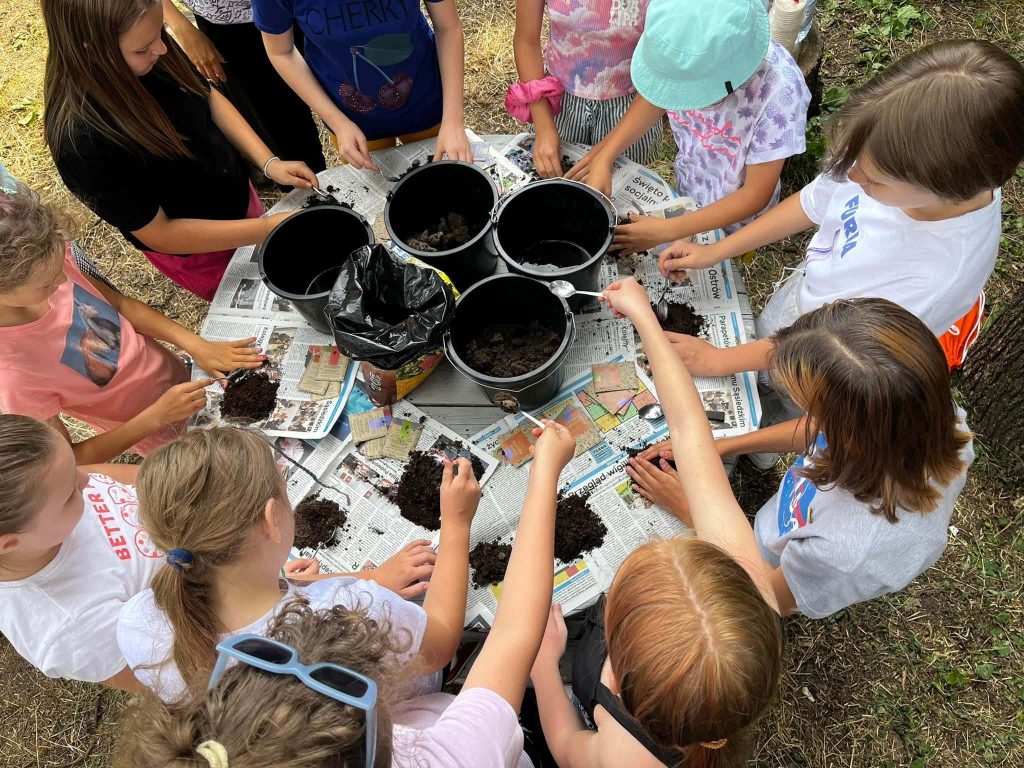 Kids seen from above, adding dirt to pots