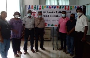 Sri lankan standing in front of the banner