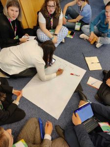 A group of young people writing "frog party" on a flipchart