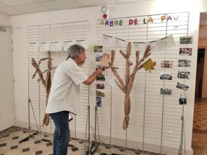 The photograph show a person interacting or pointing at what seems a informative installation inside a room