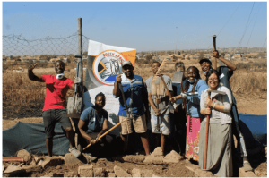 Group photo, people are holding tools for gardening and treating the land