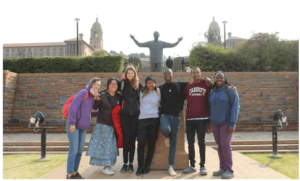 Group photo - the group is standing for a photo, behind them there is a statue