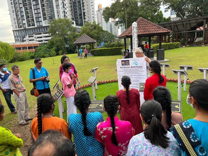 people gathered around the sign End Racism Build Peace