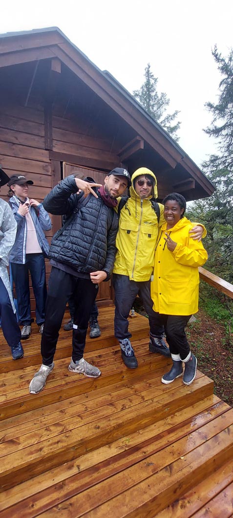 3 people wearing raincoats smiling for a picture