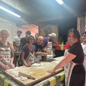 Group photo of people, it seems they are in a kitchen and were helping and preparing food