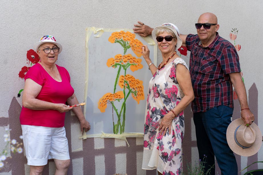 3 people showing a flower drawing