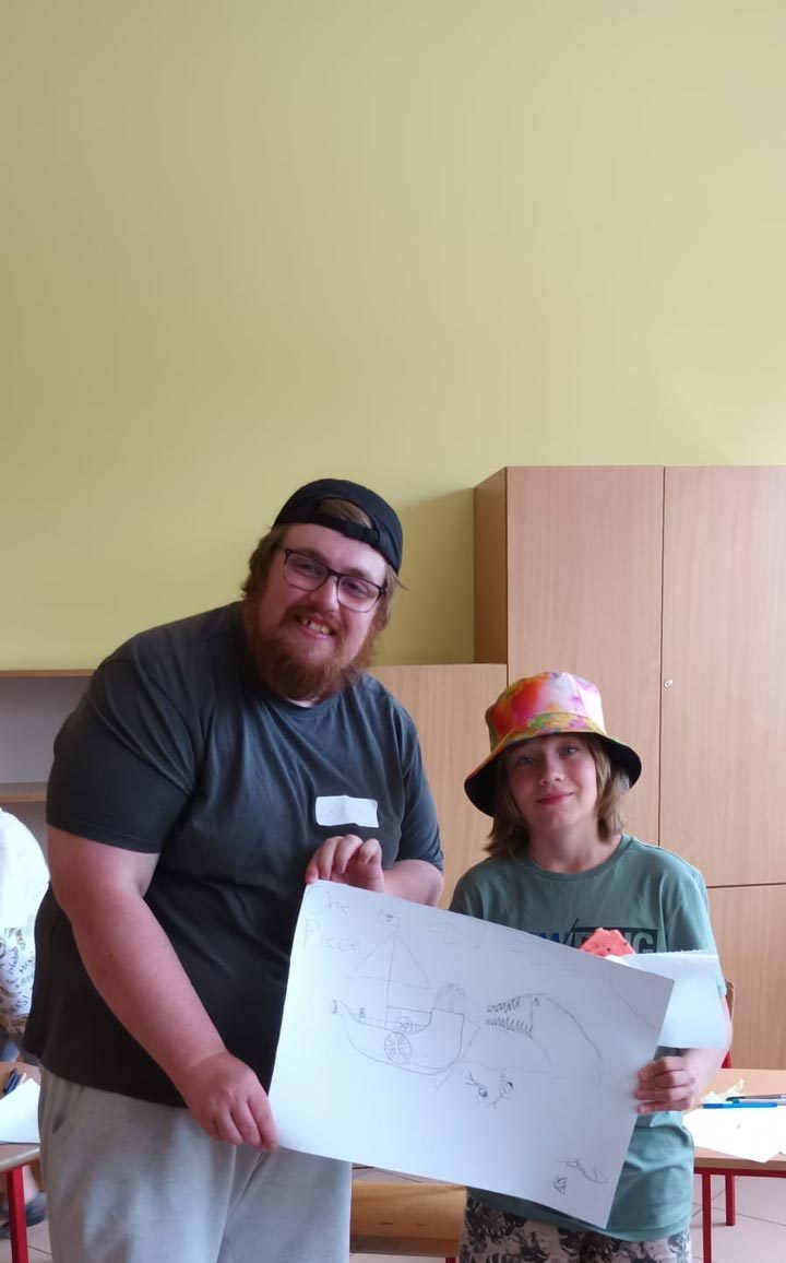 the volunteer and a kid holding a drawing