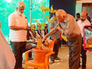 volunteers watering a plant at Sanvita ashram camp in India